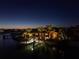Nighttime view of waterfront home, showcasing boat dock, palm trees and tiki style covered patio at 351 S Julia Cir, St Pete Beach, FL 33706
