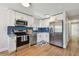 Modern kitchen featuring stainless steel appliances, white cabinets and blue subway tile backsplash at 3540 Emerson S Ave, St Petersburg, FL 33711