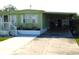 Charming single-story home featuring a covered carport, landscaped flower beds, and a cozy front porch with white railings at 36624 Kay Ave, Zephyrhills, FL 33542