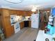 Functional kitchen with oak cabinets, white appliances, and durable laminate flooring at 36624 Kay Ave, Zephyrhills, FL 33542