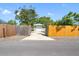 A driveway surrounded by fencing and trees leading to a detached single car garage at 4808 4Th S Ave, St Petersburg, FL 33711