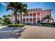 Elegant pink clubhouse exterior showcasing a circular driveway and beautiful landscaping for a welcoming ambiance at 5196 Beach Se Dr # B, St Petersburg, FL 33705