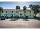Charming condo complex shows a well-maintained yellow exterior with white trim, surrounded by palm trees at 5196 Beach Se Dr # B, St Petersburg, FL 33705