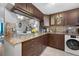 Modern kitchen featuring brown cabinetry, granite countertops, and stainless steel appliances at 6800 20Th N Ave # 309, St Petersburg, FL 33710