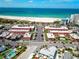 Aerial view of the beautiful community featuring a shuffleboard court, swimming pool, sandy beach, and turquoise waters at 6800 Sunset Way # 204, St Pete Beach, FL 33706