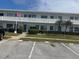Well-maintained condo building with an American flag, parking spots, and nicely landscaped bushes at 8455 112Th St # 202, Seminole, FL 33772