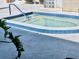 In-ground hot tub with blue tile surround and a leafy plant in the foreground at 8455 112Th St # 202, Seminole, FL 33772
