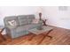 Cozy living room showcasing comfortable gray couch, glass coffee table, and wood laminate flooring at 8455 112Th St # 202, Seminole, FL 33772