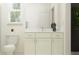 Bright bathroom with white cabinets, marble countertops, and a toilet next to a window at 9296 Gladsome Dr, Land O Lakes, FL 34637