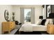 Bright bedroom features a white bed, black accents, and wooden dresser at 9296 Gladsome Dr, Land O Lakes, FL 34637