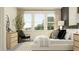 Comfortable bedroom featuring neutral tones, large windows, and a black accent chair at 9296 Gladsome Dr, Land O Lakes, FL 34637