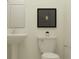 Modern powder room featuring a toilet and pedestal sink with modern decor at 9296 Gladsome Dr, Land O Lakes, FL 34637