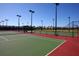 View of a tennis court and basketball court featuring professional lighting and well-maintained green and red surface at 9296 Gladsome Dr, Land O Lakes, FL 34637