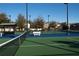 Multiple community tennis courts with a shelter, benches, and view of surrounding homes and landscaping at 9296 Gladsome Dr, Land O Lakes, FL 34637