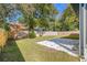 Large backyard featuring a new stone patio, surrounded by a wooden privacy fence and mature trees at 9310 N Willow Ave, Tampa, FL 33612