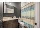 This bathroom has dark walls and cabinets, with granite countertops and a shower/tub with a colorful curtain at 9310 N Willow Ave, Tampa, FL 33612