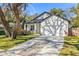 Charming home features a two-car garage, beautifully landscaped front yard, and a welcoming front porch at 9310 N Willow Ave, Tampa, FL 33612
