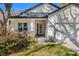 Well-manicured front exterior featuring a charming front door, lush landscaping, and a two-car garage at 9310 N Willow Ave, Tampa, FL 33612