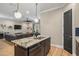 Kitchen island with granite countertop, stainless steel sink, and adjacent living space at 9310 N Willow Ave, Tampa, FL 33612