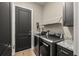 This laundry room is equipped with new washer and dryer units, with granite countertops on top of black cabinets at 9310 N Willow Ave, Tampa, FL 33612