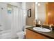Well-lit bathroom featuring a tub with shower, white shower curtain, and sleek countertop at 950 Monterey Ne Pt, St Petersburg, FL 33704