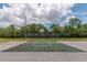 Outdoor basketball court in a fenced area with blue skies and green trees at 9845 84Th Way, Seminole, FL 33777