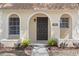 Welcoming home entrance featuring an arched entryway and meticulously maintained landscaping at 9845 84Th Way, Seminole, FL 33777