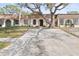 Attractive home showcasing a large driveway, mature trees, and a well-kept lawn at 9845 84Th Way, Seminole, FL 33777
