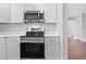 Modern kitchen with stainless steel appliances, white countertops, and white cabinets at 9845 84Th Way, Seminole, FL 33777