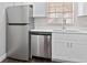 Modern kitchen with stainless steel appliances, white countertops, and ample cabinet space at 9845 84Th Way, Seminole, FL 33777