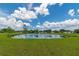 Scenic view of the pond with a fountain, surrounded by a lush, grassy lawn at 9845 84Th Way, Seminole, FL 33777