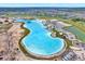 Aerial view displays a large lagoon with clear blue water and surrounding community amenities at 11486 June Briar Loop, San Antonio, FL 33576