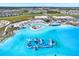 Aerial view of the resort style community pool featuring an inflatable obstacle course and sandy beach at 11486 June Briar Loop, San Antonio, FL 33576