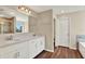Bright bathroom featuring a double vanity with white cabinets and a shower with tiled walls at 11486 June Briar Loop, San Antonio, FL 33576