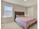 Neutral bedroom with a tufted headboard, carpet, and a bright window at 11486 June Briar Loop, San Antonio, FL 33576