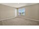 Simple bedroom featuring neutral colors, a large window, and carpet flooring at 11486 June Briar Loop, San Antonio, FL 33576