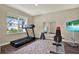 Bright exercise room featuring a treadmill, weights, weight bench, TV and neutral walls at 11486 June Briar Loop, San Antonio, FL 33576