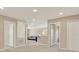Neutral hallway with several doors, leading to a sitting room with a blue couch at 11486 June Briar Loop, San Antonio, FL 33576