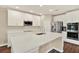Modern kitchen with stainless steel appliances, white cabinetry, and a large quartz island at 11486 June Briar Loop, San Antonio, FL 33576