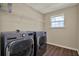 A neatly arranged laundry room featuring modern front-load washer and dryer set and wire shelving at 11486 June Briar Loop, San Antonio, FL 33576