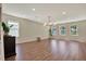 Open-concept living space featuring hardwood floors, recessed lighting, and a modern chandelier at 11486 June Briar Loop, San Antonio, FL 33576