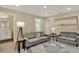 Cozy living room with a modern gray couch, contemporary art, and recessed lighting at 11486 June Briar Loop, San Antonio, FL 33576