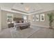 Spacious main bedroom with a tray ceiling, carpeted floor, and large windows at 11486 June Briar Loop, San Antonio, FL 33576