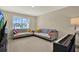 Inviting sitting room featuring comfortable sofas, large windows, and an upright piano at 11486 June Briar Loop, San Antonio, FL 33576