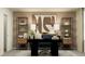 Home office with a large black desk, decorations on shelves, a comfy chair and neutral-colored walls at 11856 Blue Diamond Trl, Parrish, FL 34219
