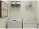 Functional laundry room with washer, dryer, shelving, and decorative storage at 11856 Blue Diamond Trl, Parrish, FL 34219