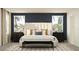 Modern primary bedroom with dark blue accent wall, white bedding, and stylish decor at 11856 Blue Diamond Trl, Parrish, FL 34219