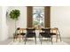 Contemporary dining room featuring a wooden table, black chairs, with a large window and simple decor at 12419 Sweet Angel Aura Way, Parrish, FL 34219