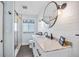 Renovated bathroom with shiplap, marble vanity, a decorative mirror, modern lighting, and a glass-enclosed shower at 1281 St Andrews Dr, Dunedin, FL 34698