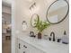 Modern bathroom featuring dual sinks with marble countertops and stylish lighting fixtures at 13414 Alpine Ave, Seminole, FL 33776